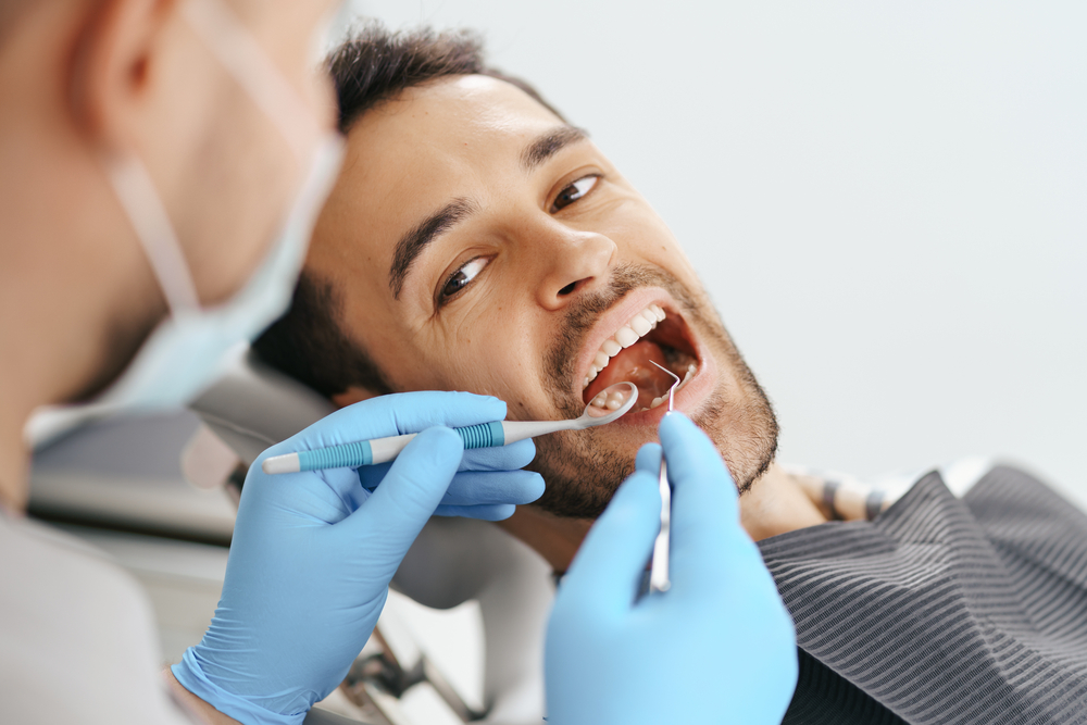 Dentist performing a root canal procedure with precision tools while patient relaxes in chair, highlighting comfortable care in La Mesa – Root Canals La Mesa
