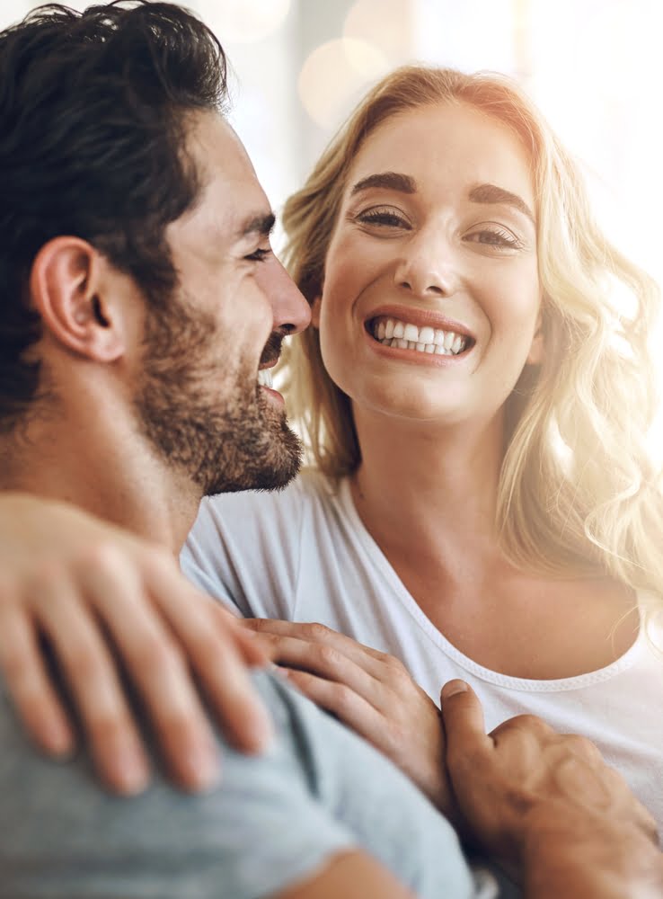 A man and a woman embrace, both smiling - Truly Yours Family Dental in La Mesa, CA